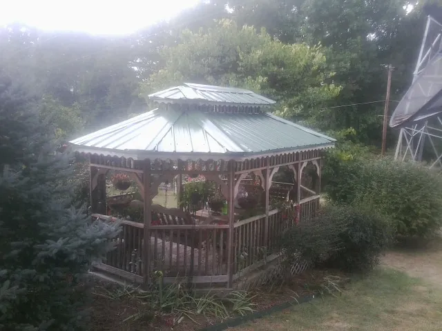 Green metal roof on a backyard gazebo surrounded by garden beds in Bridgewater